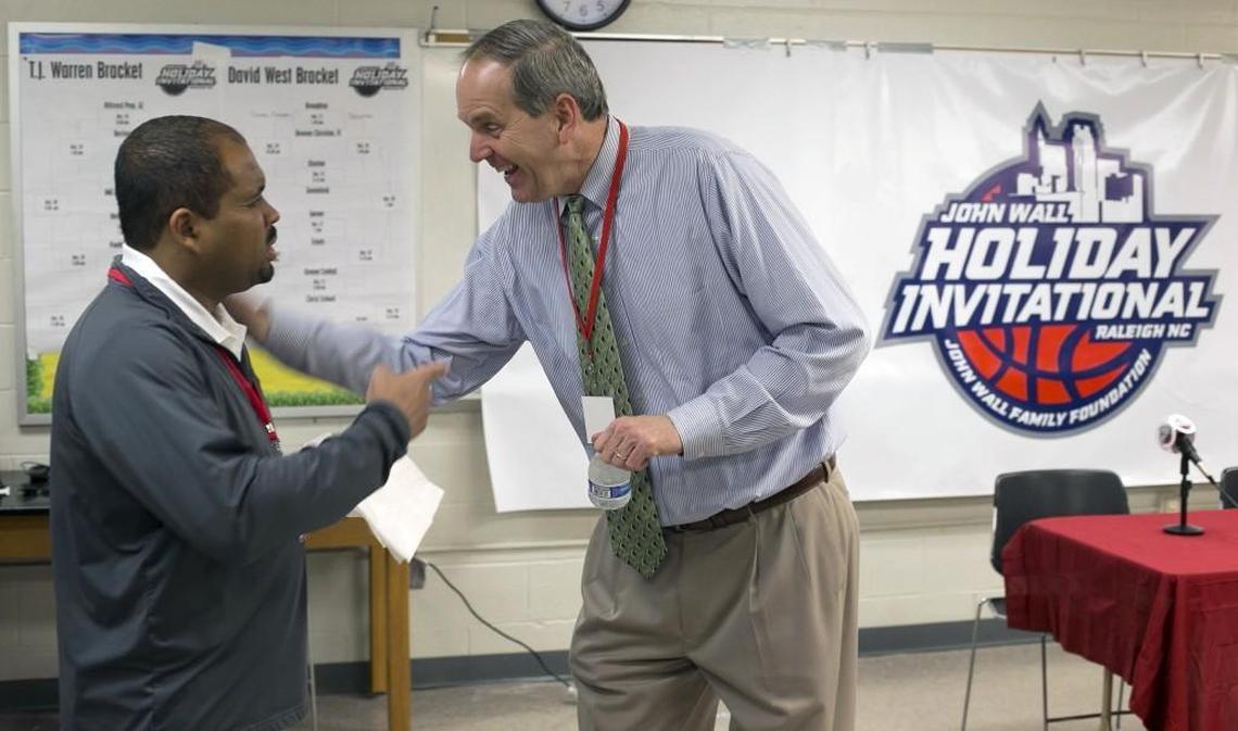 Scott Dupree, right, the executive director of the Greater Raleigh Sports Alliance, laughs with Alex Bass the sports information director for Cardinal Gibbons High School at the John Wall Family Foundation Holiday basketball tournament on Wednesday.