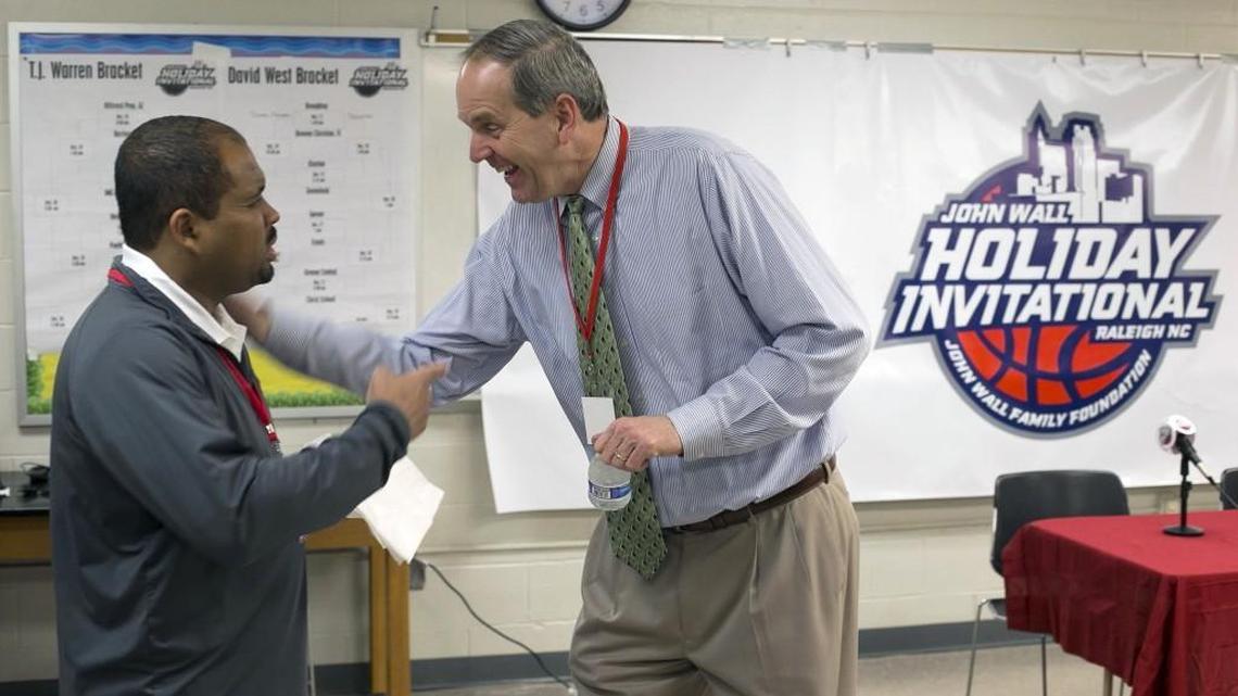 Scott Dupree, right, the executive director of the Greater Raleigh Sports Alliance, laughs with Alex Bass the sports information director for Cardinal Gibbons High School at the John Wall Family Foundation Holiday basketball tournament on Wednesday.