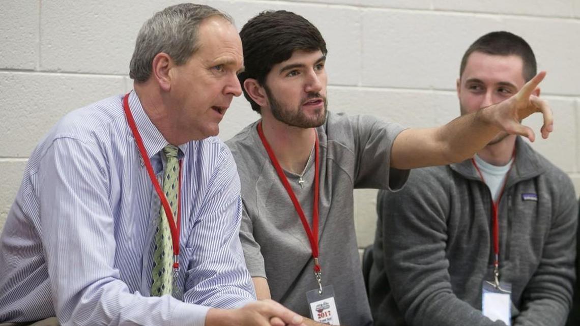 Scott Dupree, left, the executive director of the Greater Raleigh Sports Alliance, and his son Davis Dupree, center, take in a game during the John Wall Family Foundation Holiday basketball tournament on Wednesday, December 28, 2017 at Broughton High School in Raleigh, N.C.