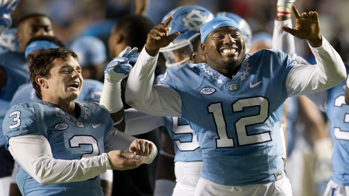 With a secure 52-14 lead over the Miami Hurricanes at the start of the fourth quarter of play, North Carolina’s Marquise Williams (12) and Ryan Switzer (3) celebrate with the student section at Kenan Stadium in Chapel Hill.