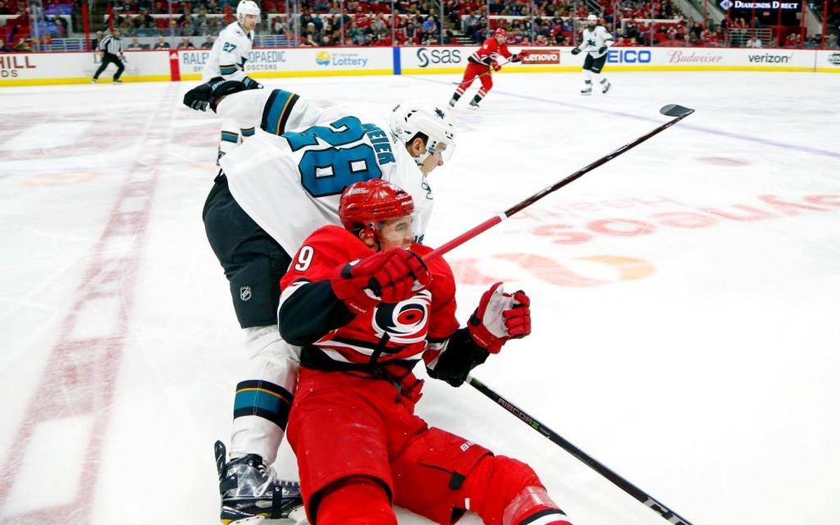 The Canes' Victor Rask (49) gets knocked down by the Sharks' Timo Meier (28) during the first period.