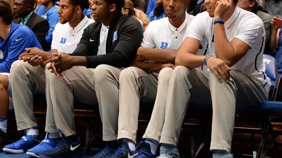 Duke freshmen (in white polo shirts) Marques Bolden, Harry Giles and Jayson Tatum sit on the bench as the Blue Devils play Marist on Nov. 11. Duke is playing shorthanded due to the injuries of the three.