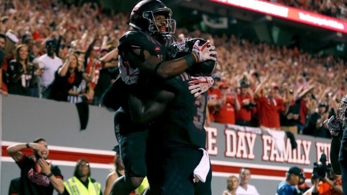 N.C. State’s Nyheim Hines, left, celebrates with Kelvin Harmon (3) after a 2-point conversion during the second half of N.C. State’s 39-25 victory over Louisville at Carter-Finley Stadium in Raleigh, NC Thursday, Oct. 5, 2017.