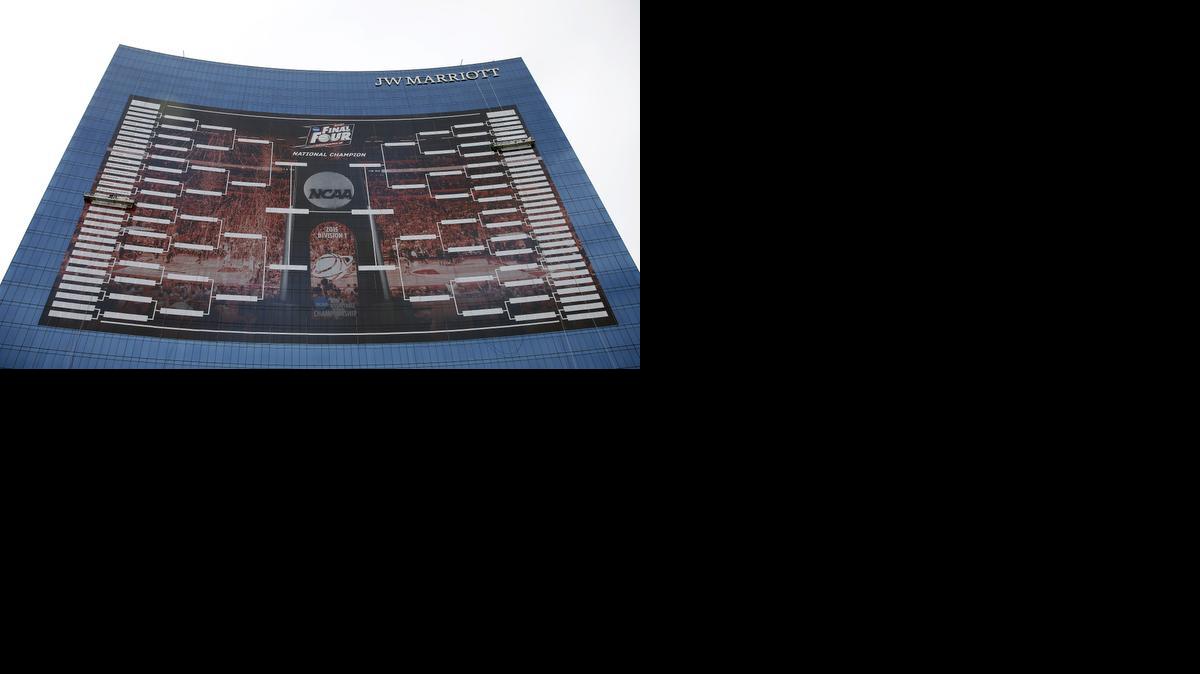 
Workers add team names to a 2015 NCAA Division I men’s basketball tournament bracket that is displayed on the side of the JW Marriott in Indianapolis on March 16. With the Final Four a week away from shining a spotlight on Indianapolis, NCAA President Mark Emmert said Thursday that the governing body for college sports is concerned about an Indiana law that could allow businesses to discriminate against gay people. 
