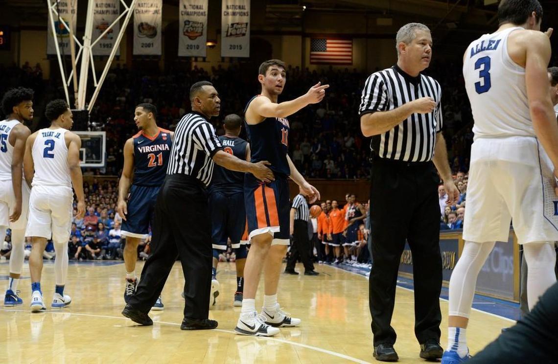Virginia guard Ty Jerome, middle, tells game officials to eject Duke guard Grayson Allen, far right, after he refused to let Virginia guard Kyle Guy help him off the floor near the end of Virginia’s 65-63 win. Guy hit Allen with what was determined to be an inadvertent elbow as he was caught in a trap near the end of the game on Saturday.