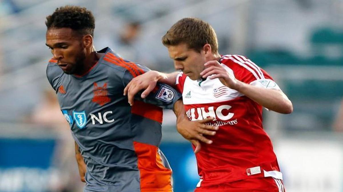 Carolina's Matt Watson, left, keeps the ball from New England's Scott Caldwell during the first half at WakeMed Soccer Park in Cary.