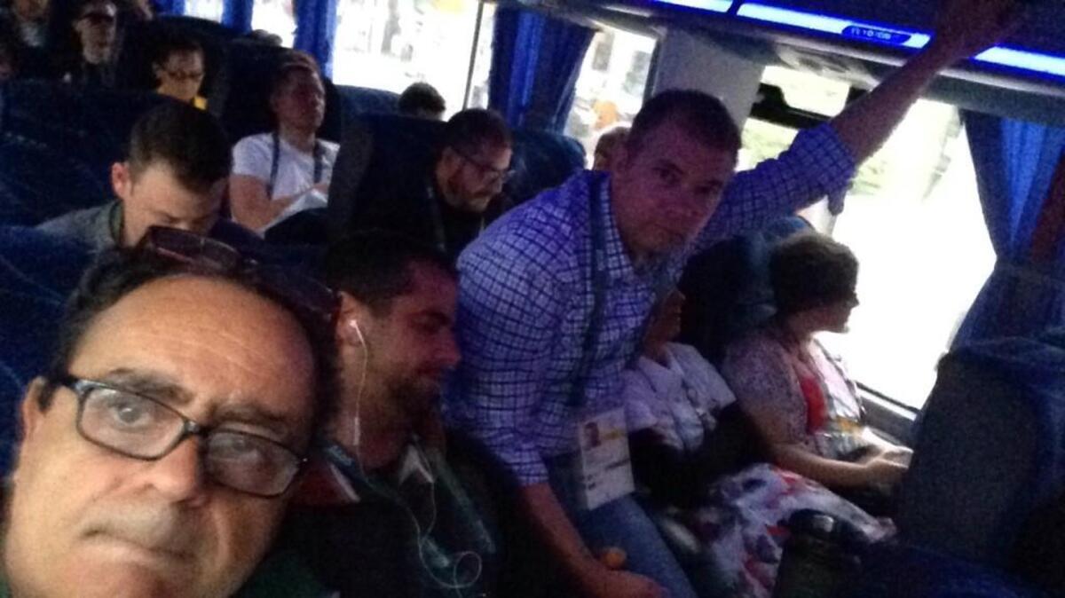A Brazilian photographer (pictured lower left) captured this picture of me riding in the aisle of a full bus, sitting on a photographer’s gear case.