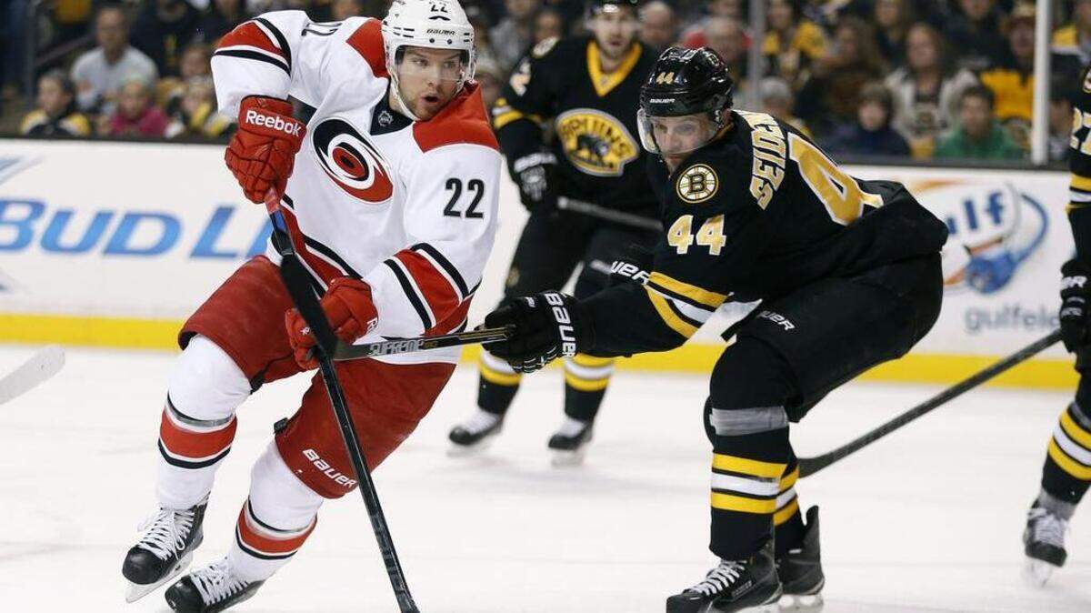 Boston Bruins' Dennis Seidenberg (44), of Germany, defends against Carolina Hurricanes' Zach Boychuk (22) during the first period of an NHL hockey game in Boston, Saturday, Nov. 15, 2014. (AP Photo/Michael Dwyer)