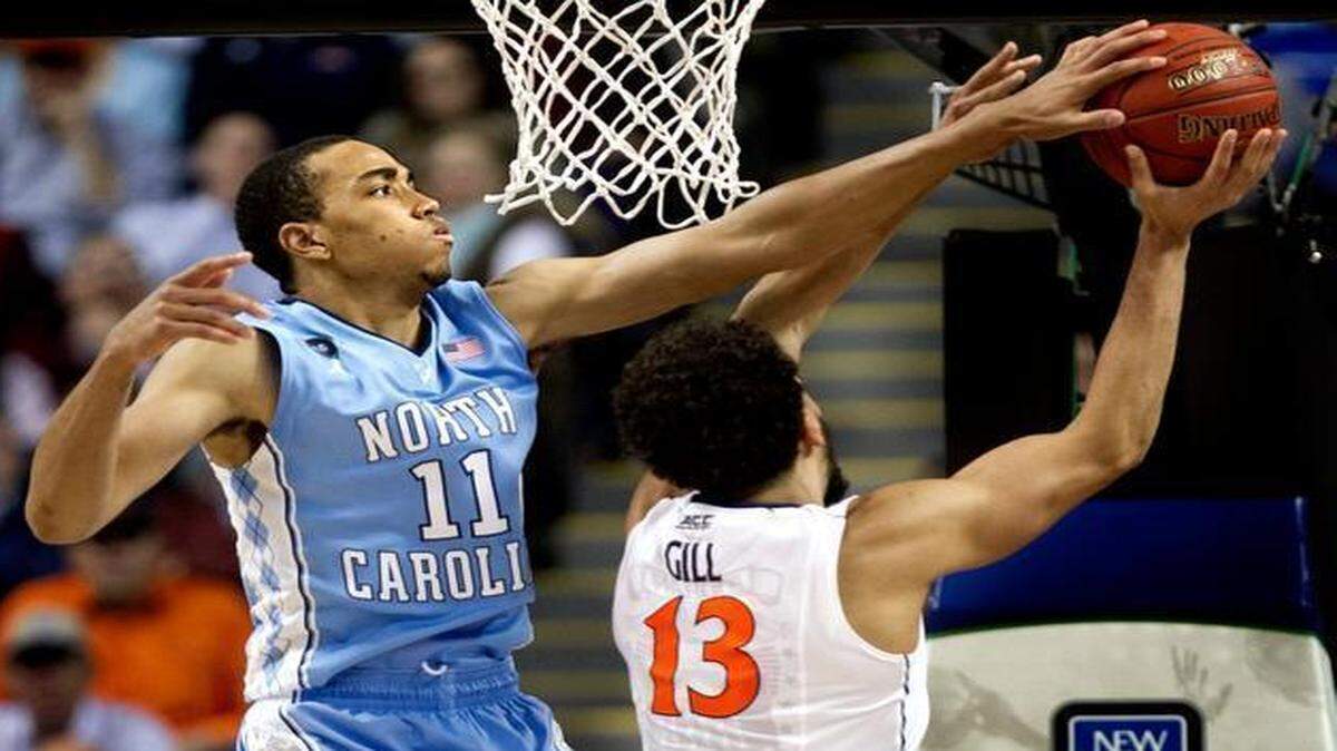 
Virginia’s Anthony Gill has trouble getting past North Carolina’s Brice Johnson during the second half of Friday’s semifinal of the ACC tournament in Greensboro. The Tar Heels won 71-67 and will play in Saturday night’s championship game.
