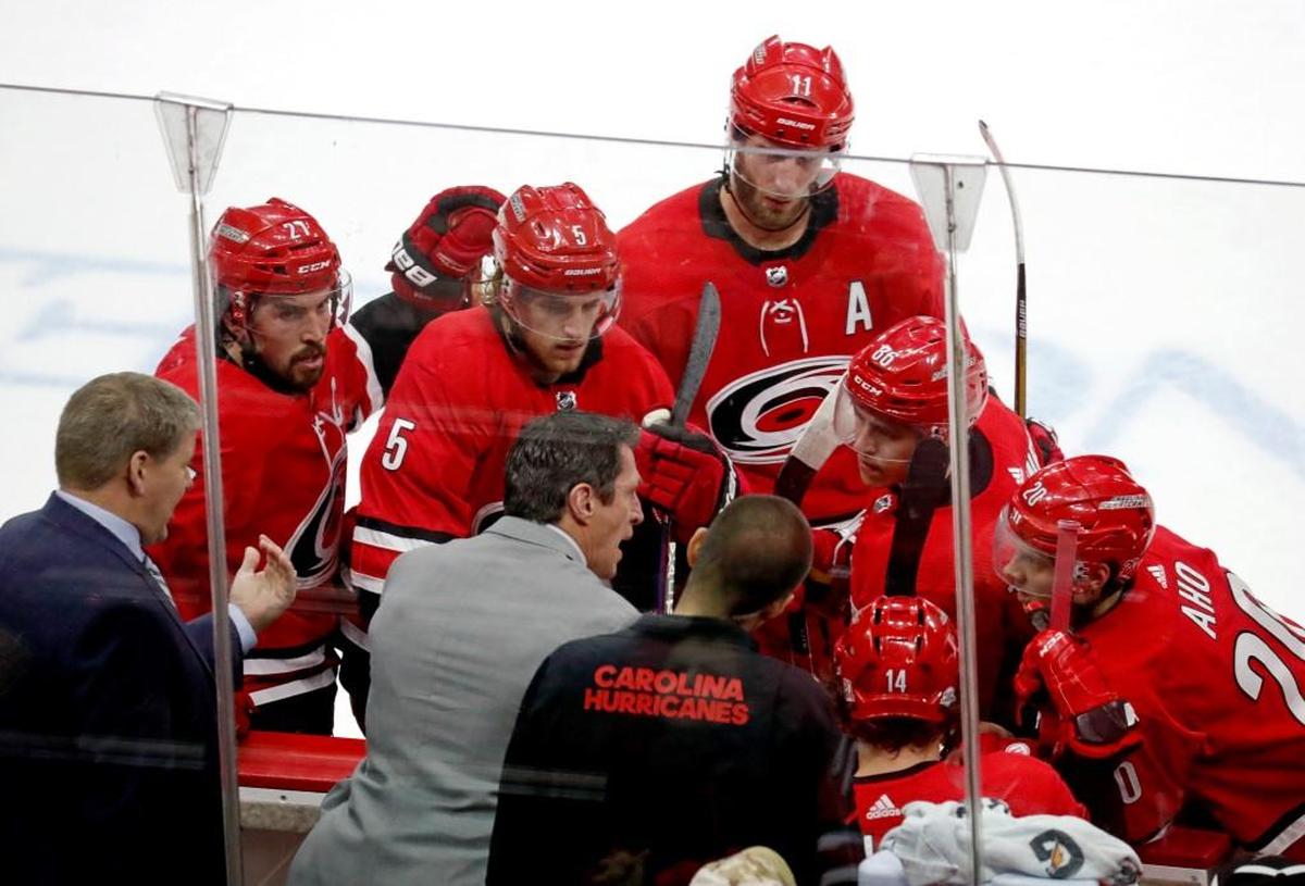 The Canes' head coach Bill Peters, left, and assistant coach Rod Brind'Amour, center, try to come up with a plan to score during a time out in the final minutes against the San Jose Sharks at PNC Arena on Feb. 4, 2018. The Sharks beat the Canes 3-1.