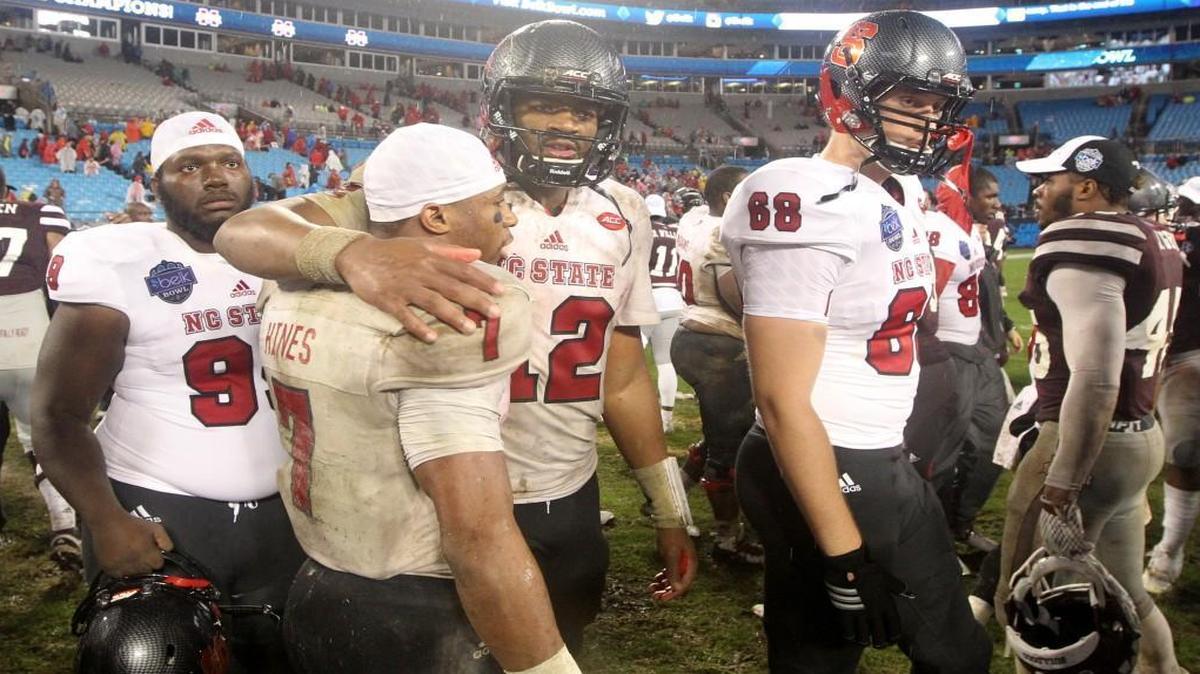 N.C. State’s Nyheim Hines (7) hugs quarterback Jacoby Brissett (12) after Mississippi State’s 51-28 victory over N.C. State in the Belk Bowl on Wednesday.