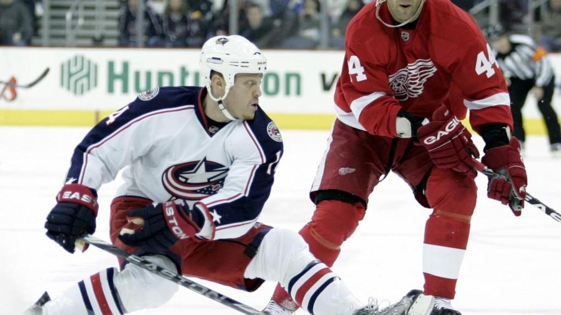 Raffi Torres, left, then with the Columbus Blue Jackets, tries to control the puck in front of Detroit Red Wings' Todd Bertuzzi during the first period of an NHL hockey game in Columbus, Ohio, in 2009. (AP Photo/Paul Vernon)
