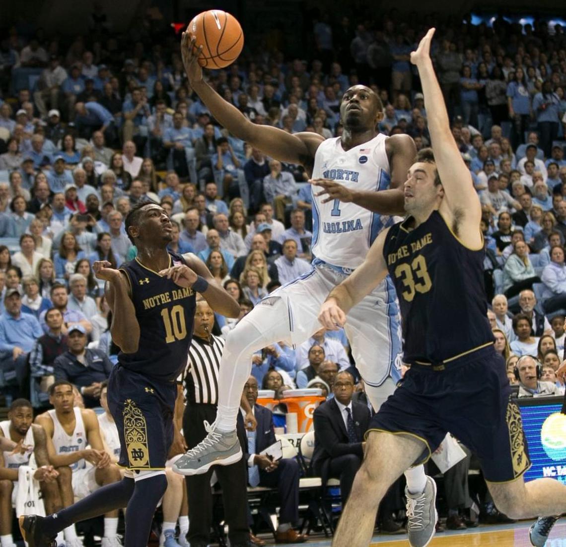 North Carolina’s Theo Pinson (1) drives between Notre Dame’s T.J. Gibbs (10) and John Mooney (33) during the second half on Monday, February 12, 2018 at the Smith Center in Chapel Hill, N.C.