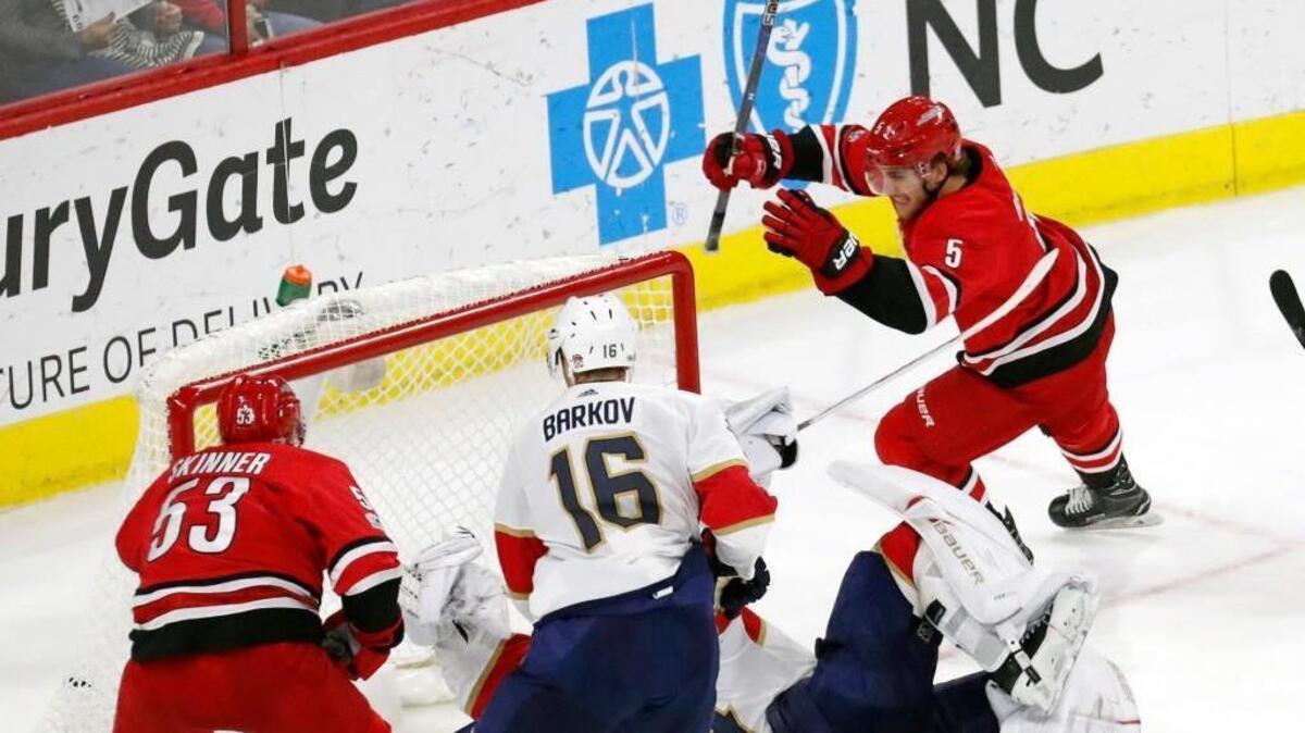 The Canes' Noah Hanifin (5) celebrates his game winning goal with Jeff Skinner (53) after he scored against the Panthers' Aleksander Barkov (16) and James Reimer (34) during the overtime period of an NHL game played between the Carolina Hurricanes and the Florida Panthers at PNC Arena in Raleigh, N.C. on Dec. 2, 2017. The Canes beat the Panthers 3-2 in overtime.
