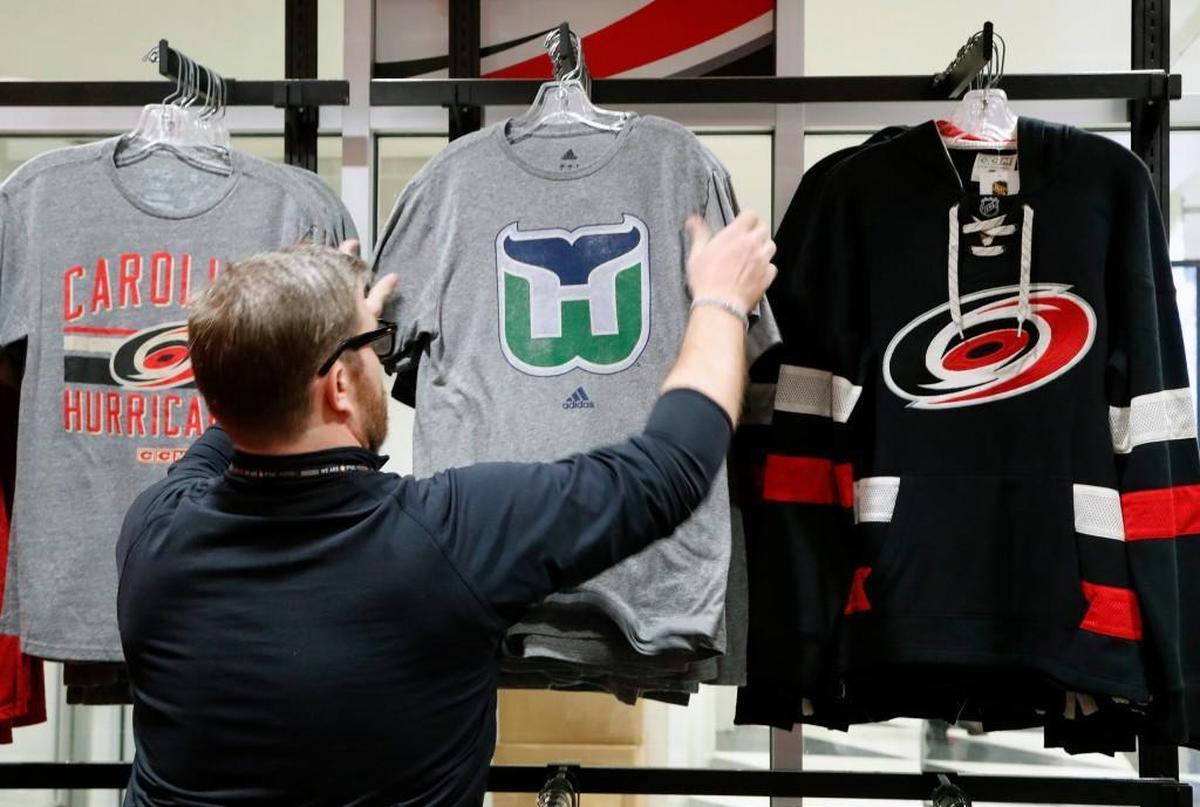 Kurt Cusac, a worker at The Eye store, straightens out the Hartford Whalers tee shirts before the doors open before a Carolina Hurricanes game in Raleigh on Feb. 1, 2018.
