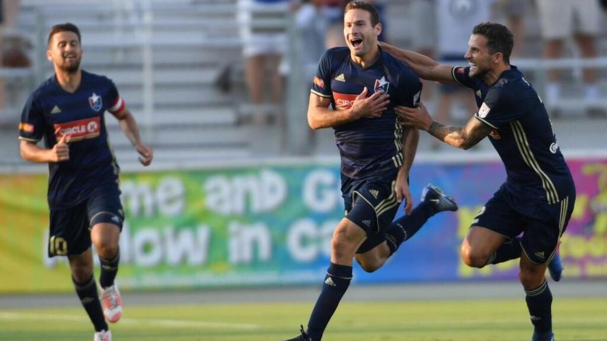 Steven Miller, center, of North Carolina F.C. celebrates with Nazmi Albadawi, left, and Paul Black, right, after scoring goal against the Houston Dynamo at the WakeMed Soccer Park in Cary on June 14, 2017. Dynamo won 3-2 in overtime.