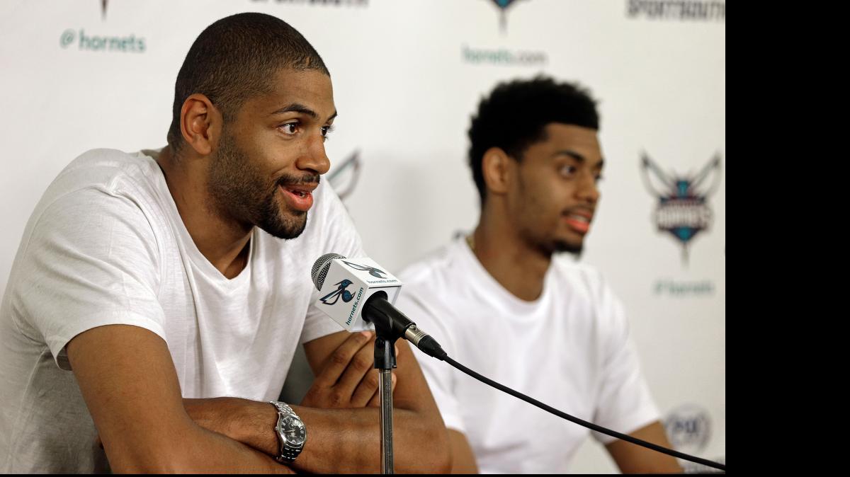 
Charlotte Hornets' newly acquired player Nicolas Batum, left, answers a question as Jeremy Lamb, right, listens during a new conference last month at Time Warner Cable Arena.

