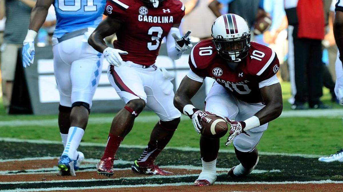 
South Carolina Gamecocks' Skai Moore (10) celebrates with Chris Lammons (3) after intercepting a North Carolina Tar Heels pass in the end zone  in the Belk College Kickoff season opener at Bank of America Stadium on Thursday. 
